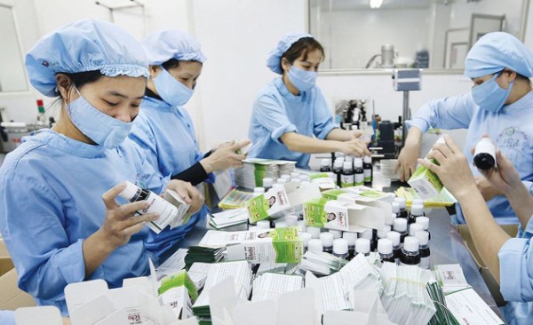 ベトナム経済考察：新型コロナ影響と2022年予測。薬を詰めるベトナム人女性